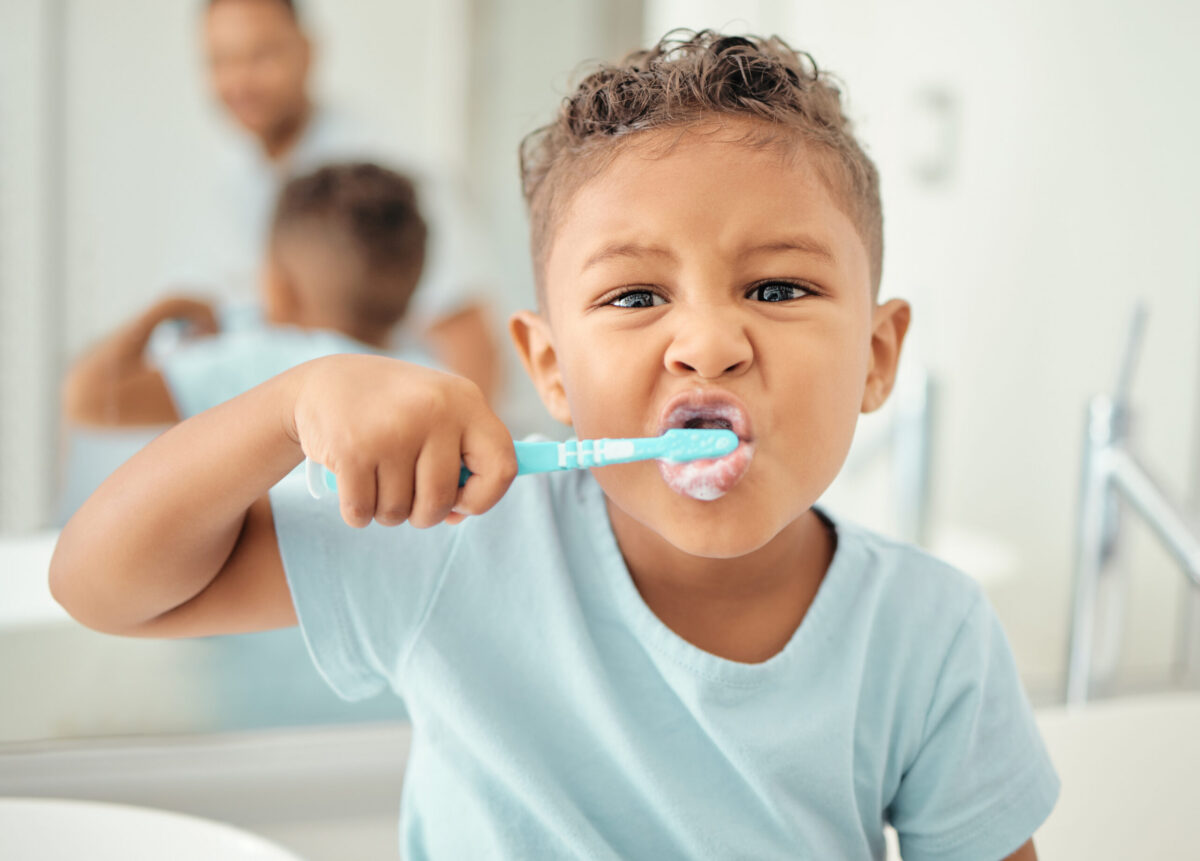 A child brushing their teeth at the bathroom sink